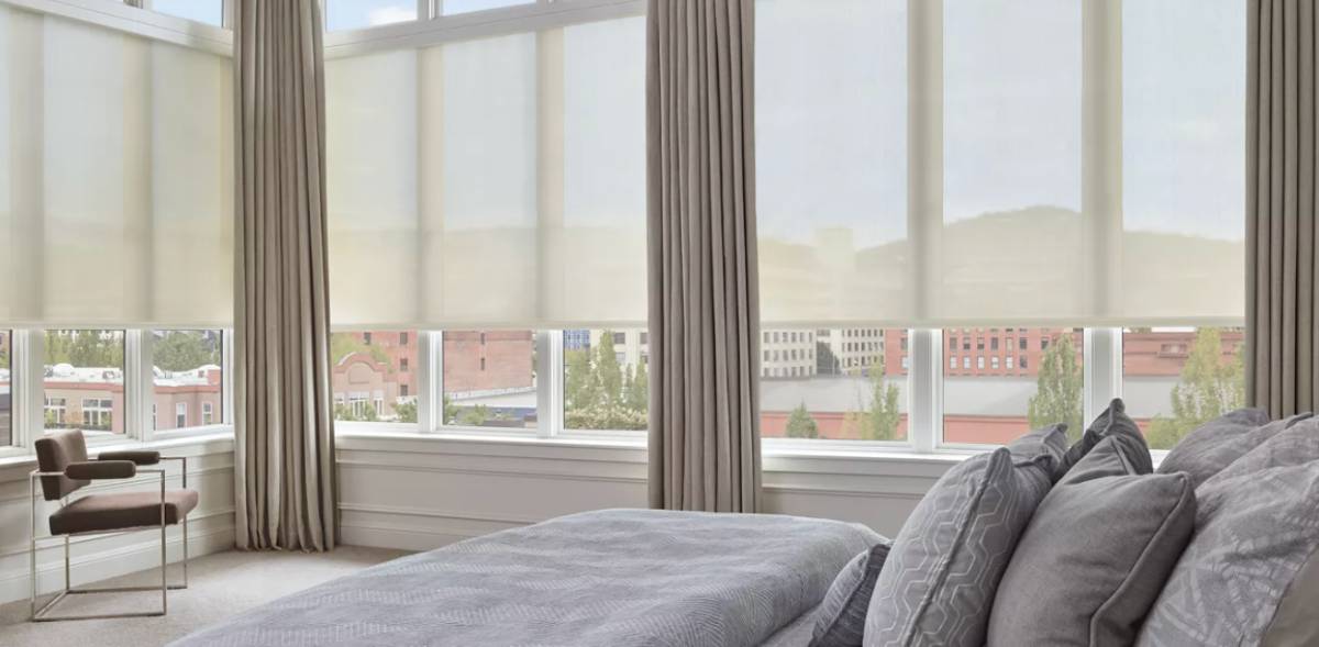Hunter Douglas solar shades covering multiple windows in a contemporary bedroom near Richmond, VA
