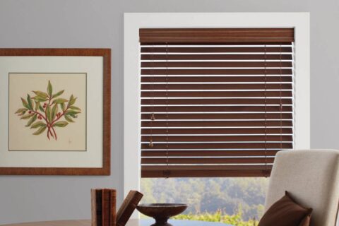 Hunter Douglas Everwood® Faux Wood Blinds covering a window in a rustic living room