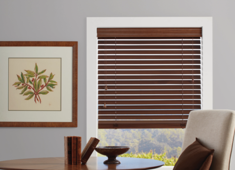 Hunter Douglas Everwood® Faux Wood Blinds covering a window in a rustic living room.