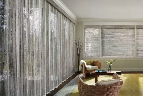 Hunter Douglas Provenance® Woven Wood Shades covering multiple windows in a boho living room.