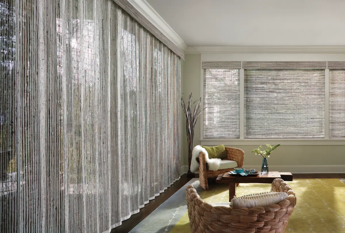 Hunter Douglas Provenance® Woven Wood Shades covering multiple windows in a boho living room.